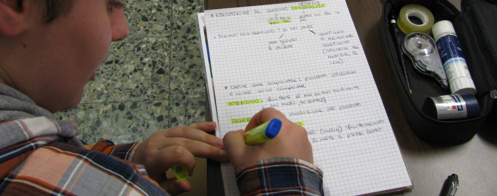 Foto di un ragazzo che prende appunti durante una lezione scolastica