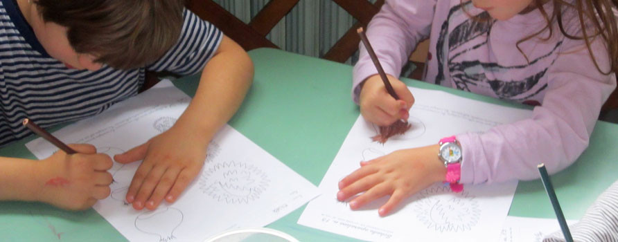 Bambini intenti a colorare dei disegni